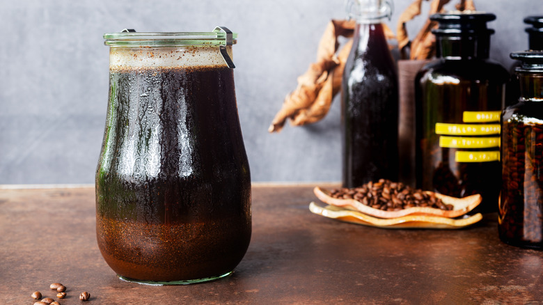 A large jar of cold brew coffee on a wooden countertop