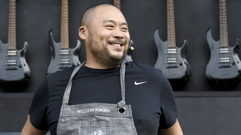 Chef David Chang smiles in front of guitar display