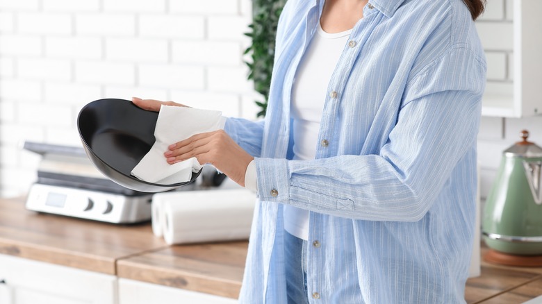 Woman drying a bowl with a paper towel