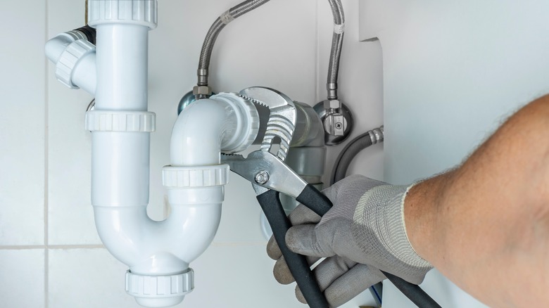 Plumber unclogging a siphon pipe