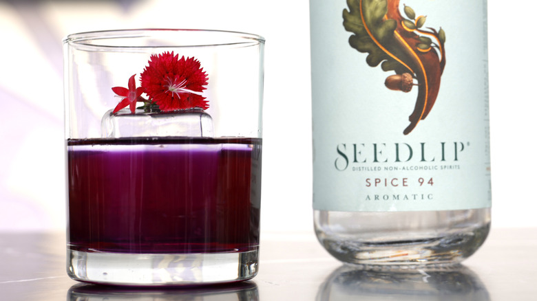 A non alcoholic cocktail with a bottle of Seedlip spirit