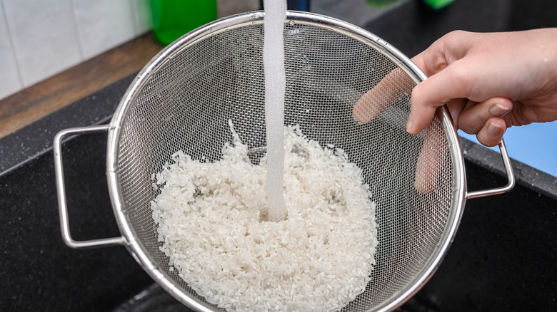 Rinsing rice in a mesh strainer.