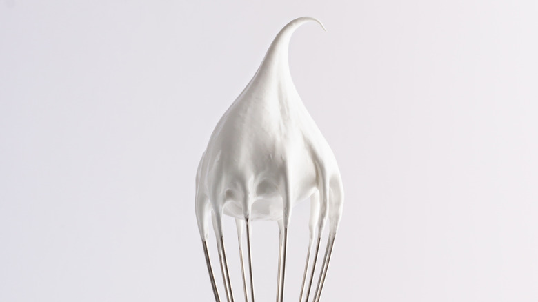 Close up of a whipped egg whites on a whisk