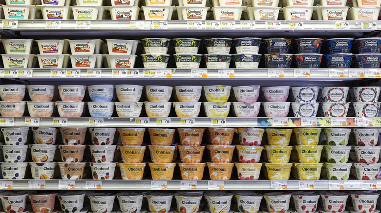 Grocery store shelf full of yogurts of different flavors