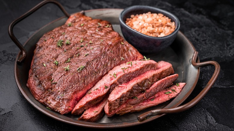 Sirloin steak in pan on black table