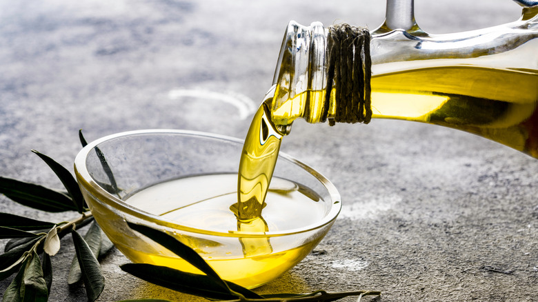 pouring olive oil into glass bowl