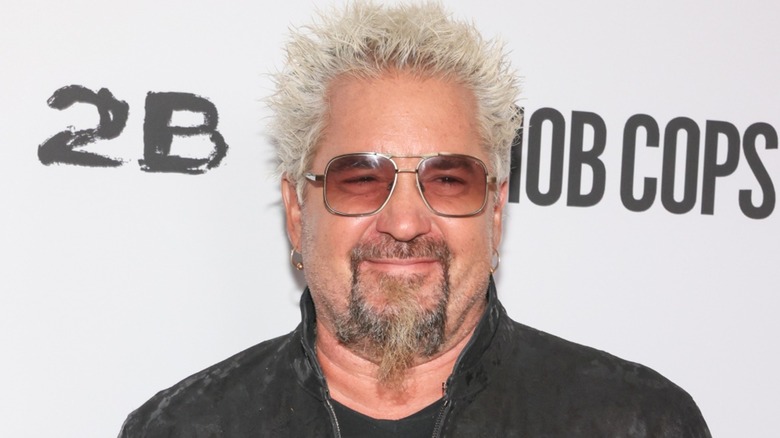 Guy Fieri poses in sunglasses at an event