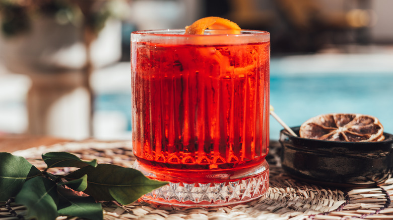 A Negroni cocktail with ice and an orange peel