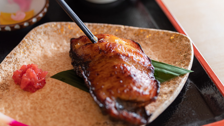 Marinated fish on a plate with ginger