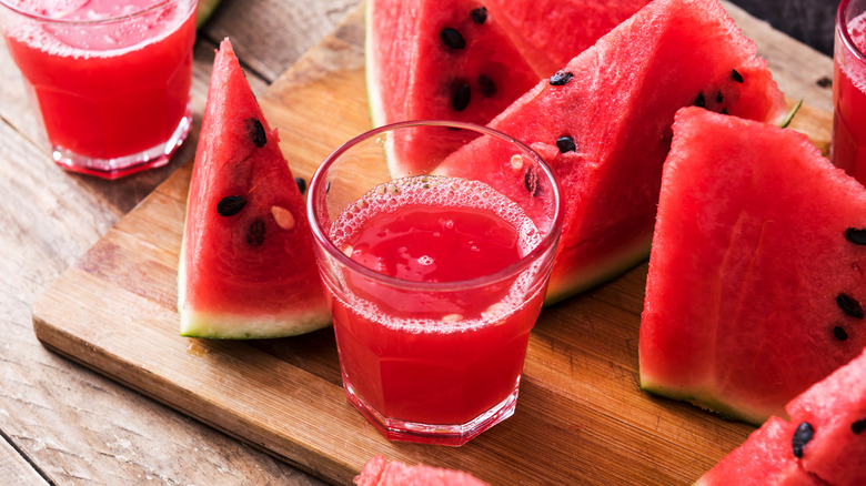 Glasses of fresh watermelon juice next to watermelon slices