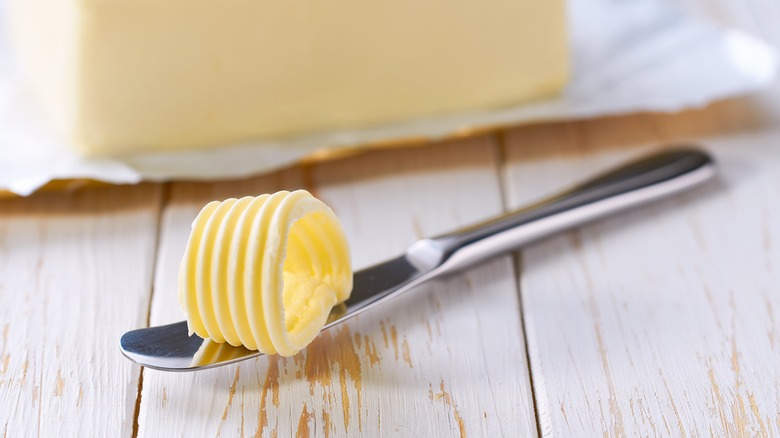 A block of butter with a knife.