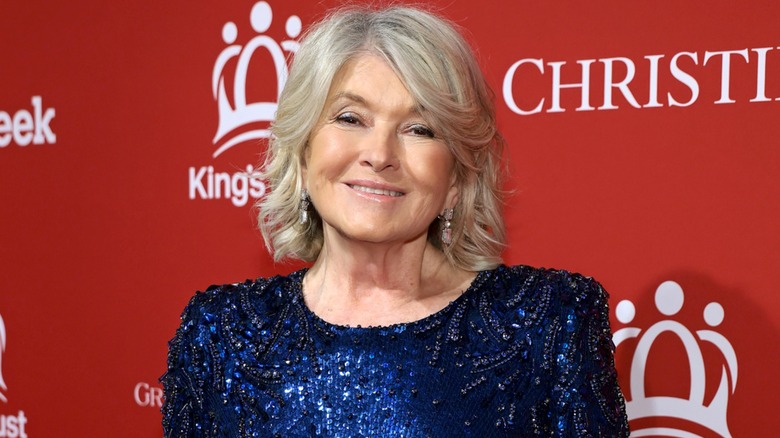 Martha Stewart posing for photograph at a red carpet event in a sequined blue dress.