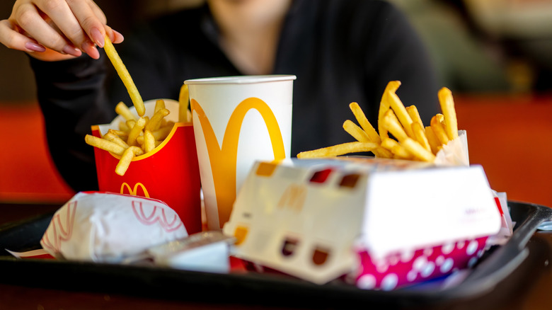 A closeup of McDonald's meal with fries, burger, and drink with boxes