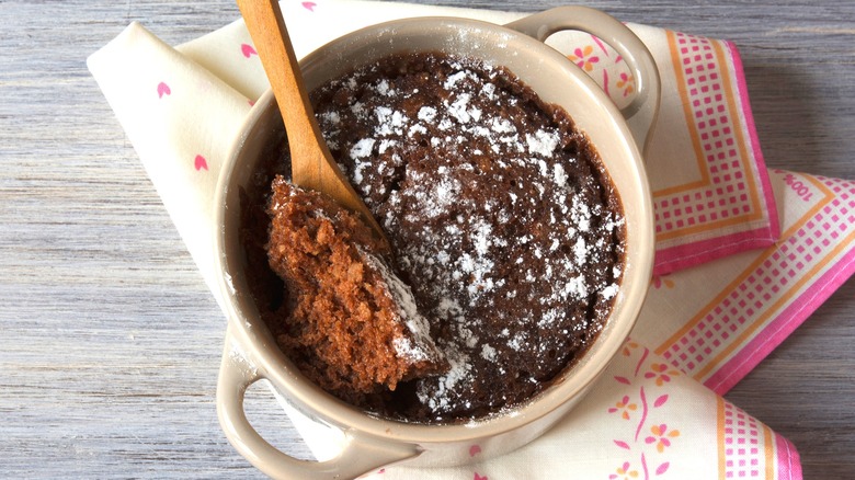 A chocolate mug cake dusted with sugar