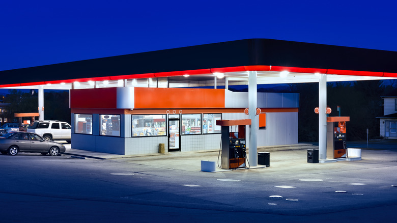 a lit-up gas station with convenience store at dusk