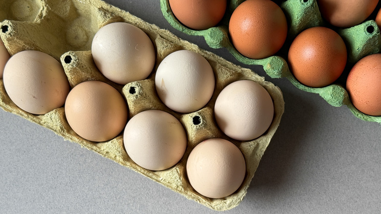 White and brown eggs in open cardboard trays