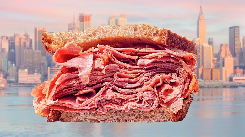 Thick pastrami sandwich in front of the New York City skyline