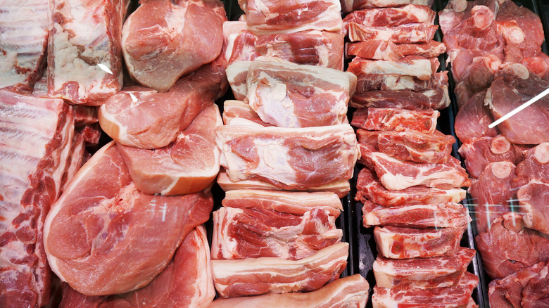 Various types of meat on the counter, including pork and beef