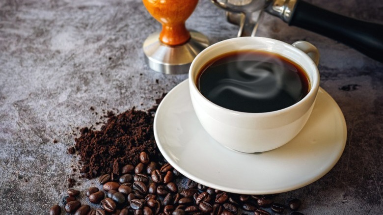 A cup of coffee with beans.