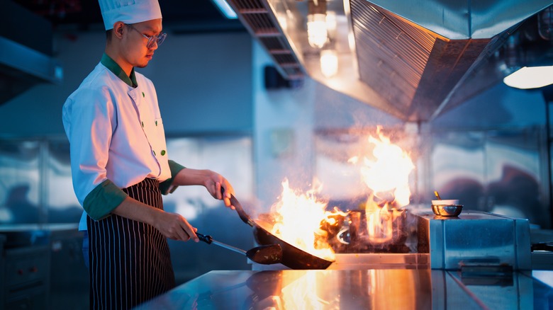 Chef cooking with pan on fire