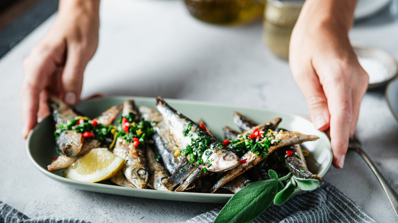 Hands serving anchovies