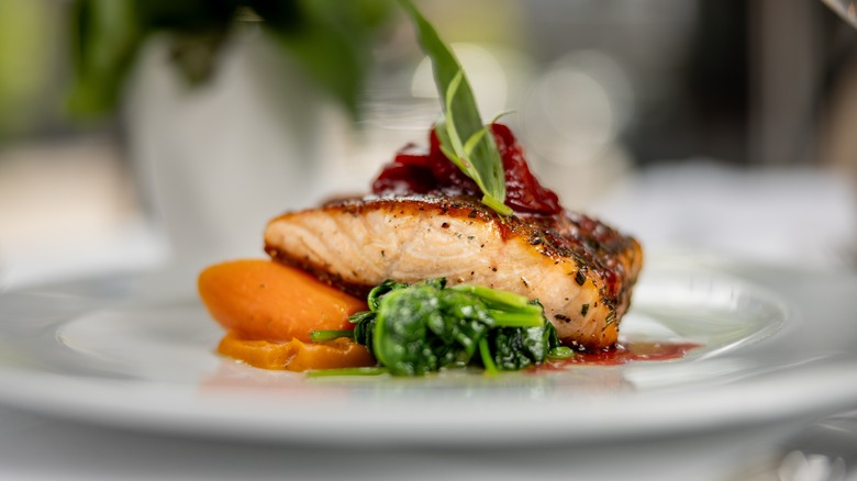 fancy salmon dish with carrots and greens