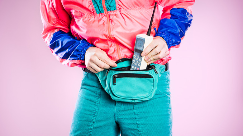 Torso of person wearing bright colors, fanny pack, large phone