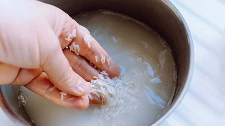 hand washing rice in rice cooker bowl