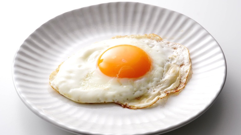 A sunny side up fried egg with an orange yolk.