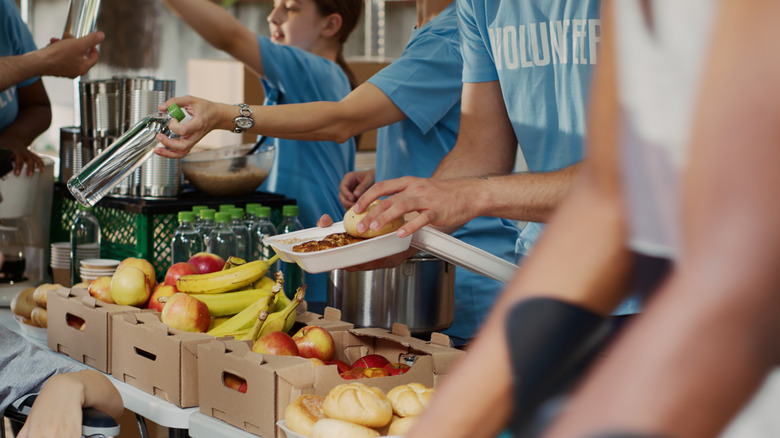 Food donations being passed out by people wearing blue volunteer shirts