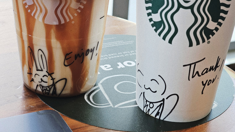 Two Starbucks cups with writing on