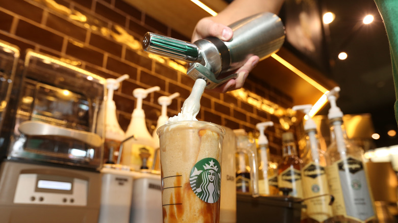 A Starbucks barista finishing making a drink