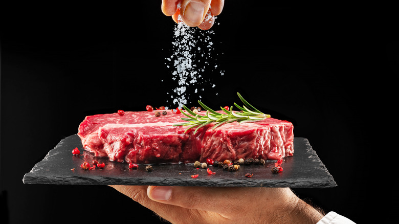 hand salting a raw steak