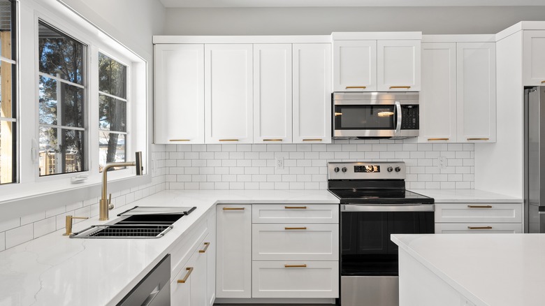 White kitchen with white cabinets and a gap above the counters