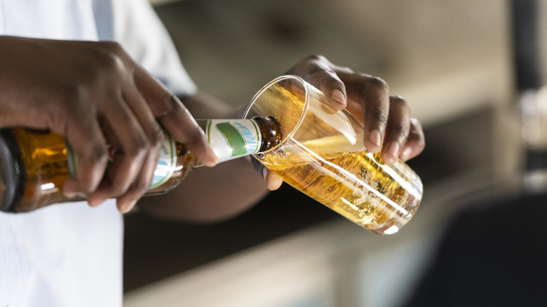 A man pours fresh beer into a glass