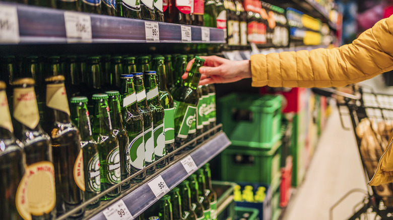A woman grabs room temperature bottle of beer