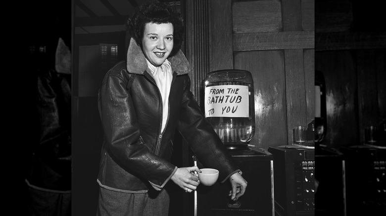 A woman pours bathtub gin from a water cooler