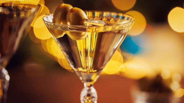 A martini with two olives in a crystal cocktail glass