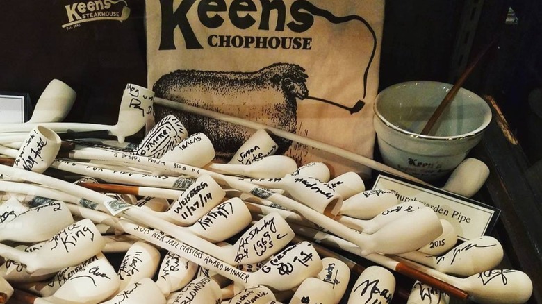 Some of Keens Steakhouse's signed pipes sitting on a table.
