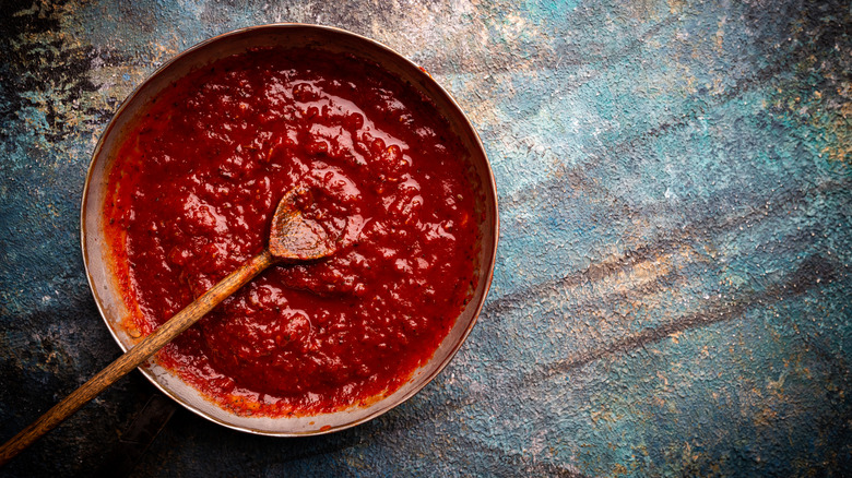 Tomato sauce in a bowl with a wooden spoon