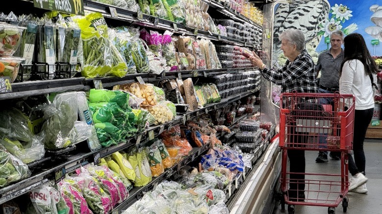 An older woman shops produce at Trader Joe's