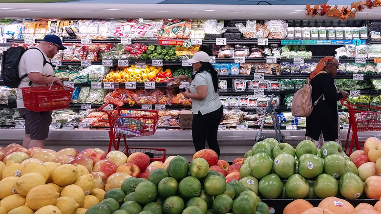 Aisle inside Trader Joe's with produce and shoppers.