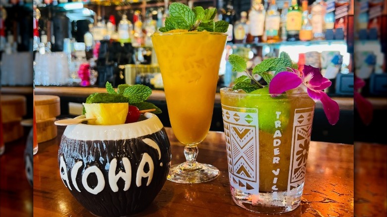 Several cocktails on the bar at a Trader Vic's Tiki Bar.