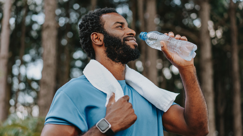 Man drinking water out of plastic water bottle