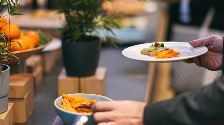 A diner at a buffet assembling his plate.