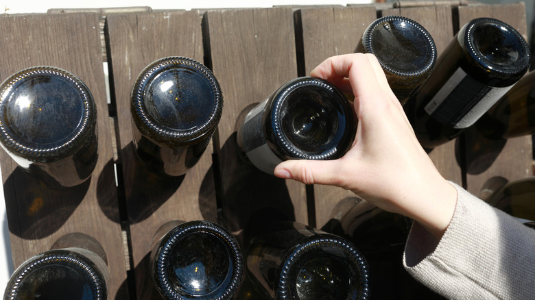 hand grabs a wine bottle with the dented punt