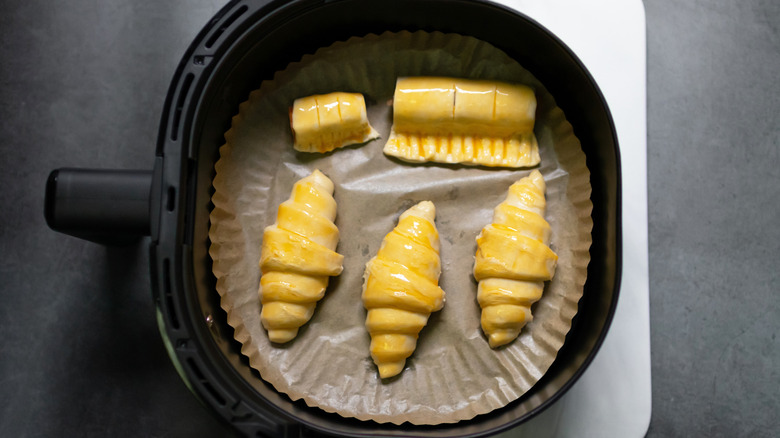 Top view of croissants and puff pastry in air fryer basket