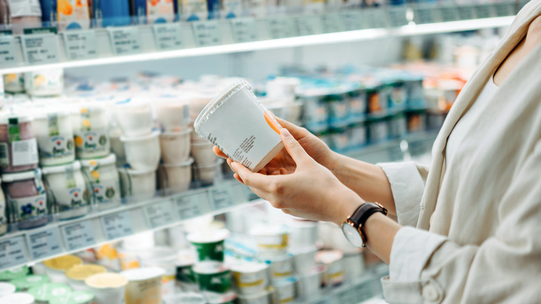 Hand holding product container of yogurt