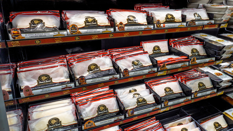 A deli case full of packages of Boar's Head deli meat in neat rows.