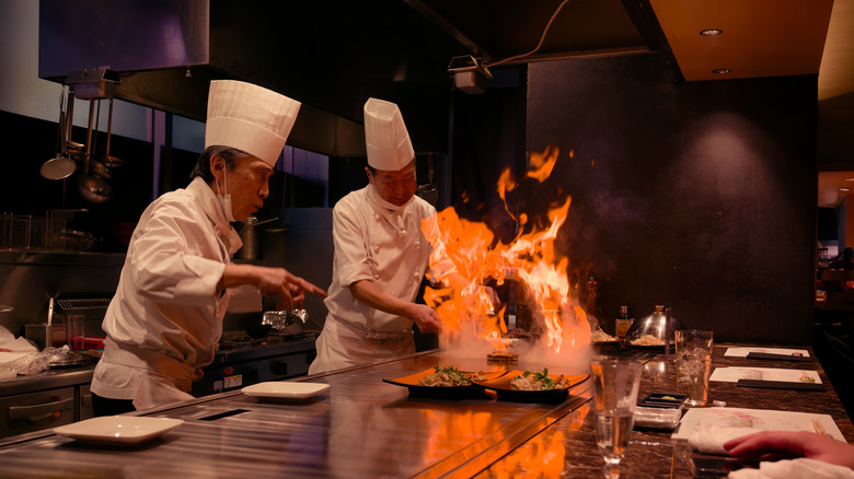 Hibachi restaurant chefs cooking with fire